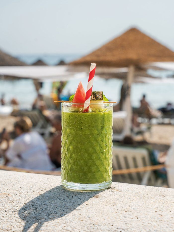 A green juice in front of the sea.