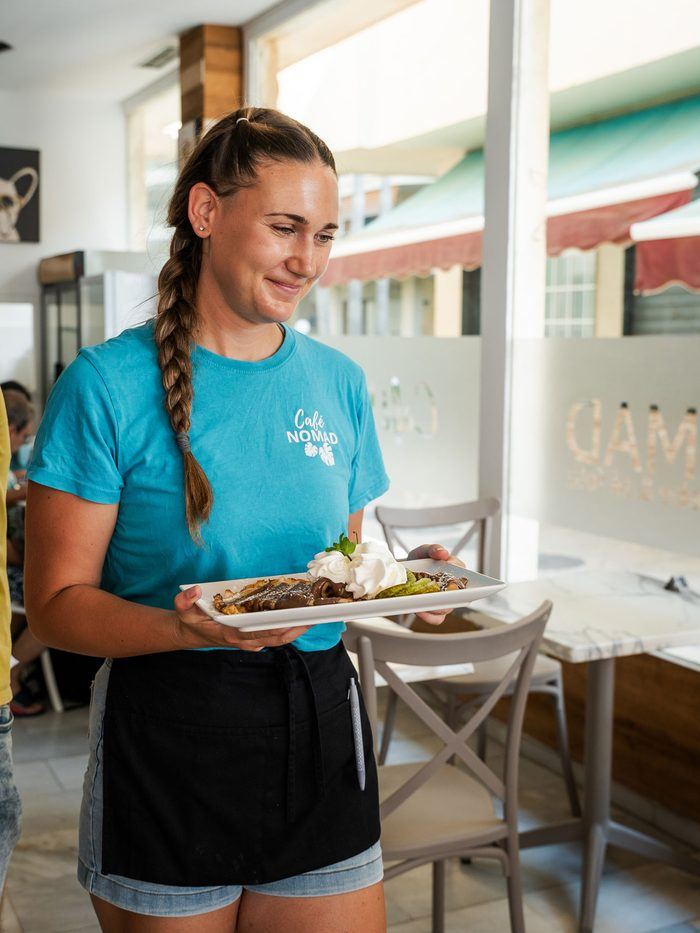 A server crossing the room with a plate.